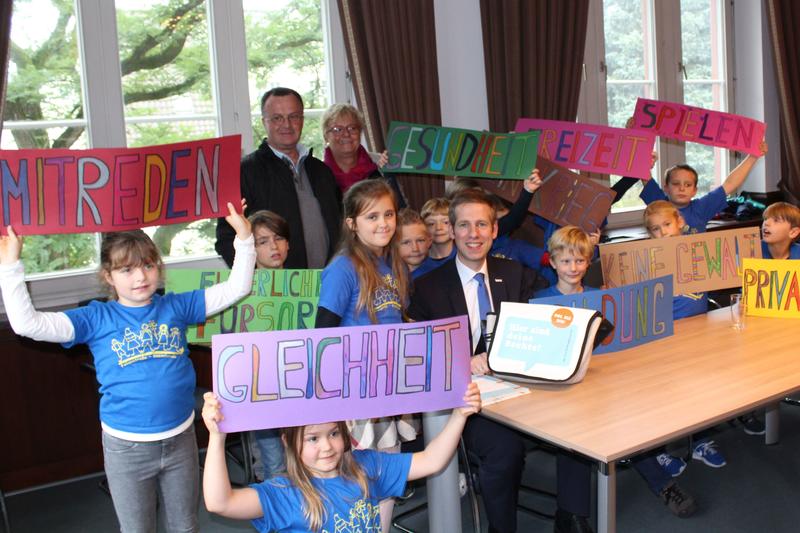 Das Bild Schülerinnen und Schüler der Grundschule mit Bürgermeister Christoph Schultz bei der Übergabe der Kinderrechtetasche.