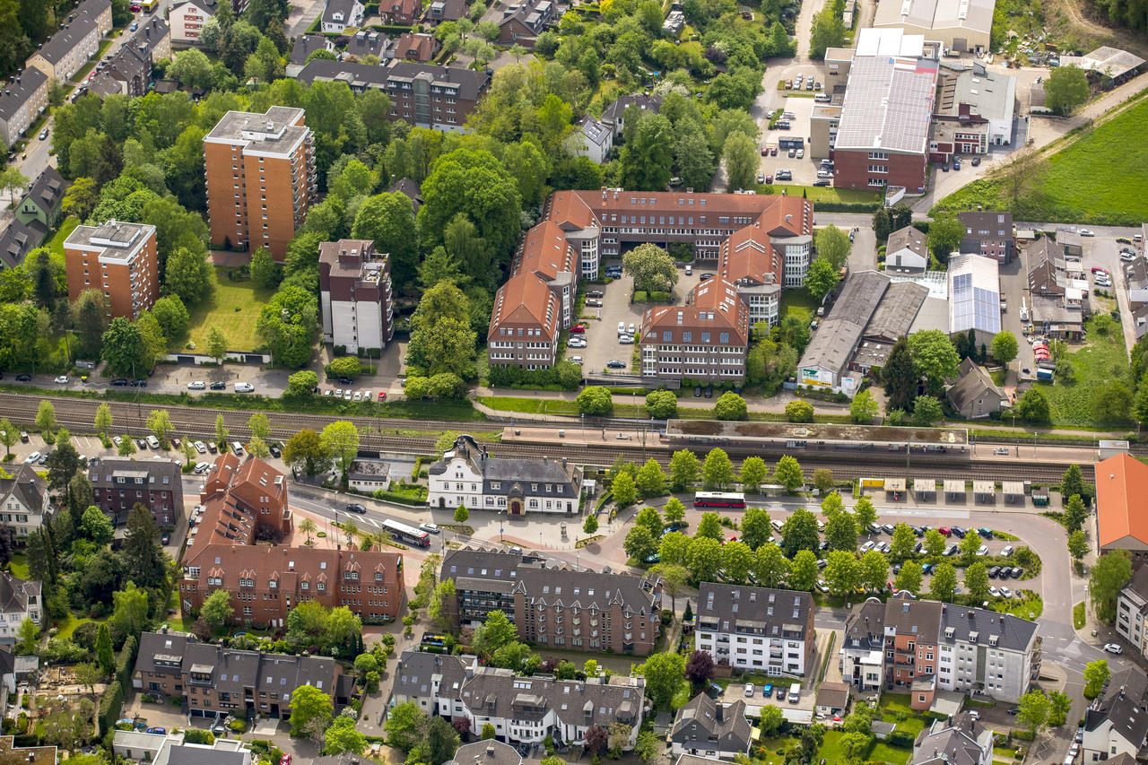 Luftbild in Richtung Süden in Alt-Erkrath. Blick auf den Kaiserhof, das ehemalige Bahnhofsgebäude, die Bahnschienen und das dahinterliegende Gewerbegebiet (© Hans Blossey)