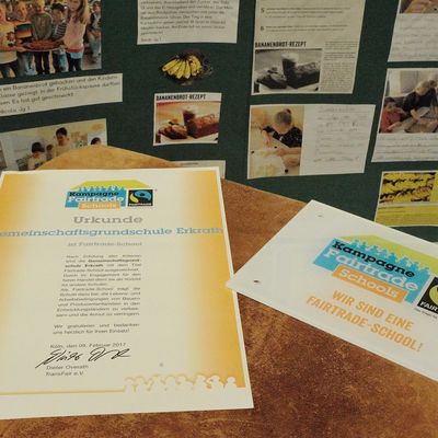 Zertifizierungsurkunde und Schild mit der Aufschrift KampagneFairtrade Schools