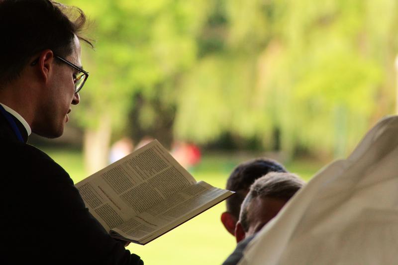Ein Pfarrer liest aus der Bibel vor.