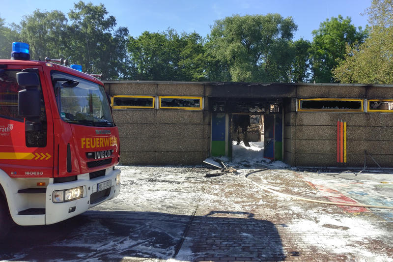 Das ausgebrannte Gebäude der Grundschule Sandheide mit einem Feuerwehrwagen davor.