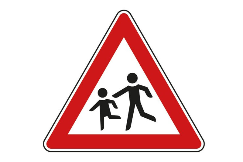 Das Bild zeigt ein dreieckiges Verkehrsschild, das auf Kinder aufmerksam machen soll.
