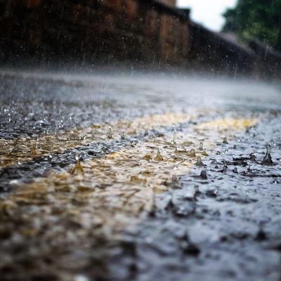 Eine Straße steht bei starkem Niederschlag unter Wasser.