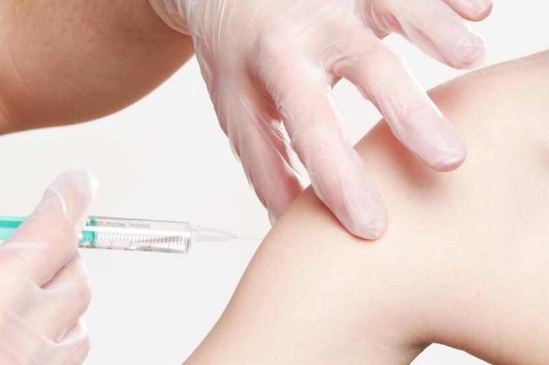 Eine Frau erhält eine Impfung in den Oberarm.
