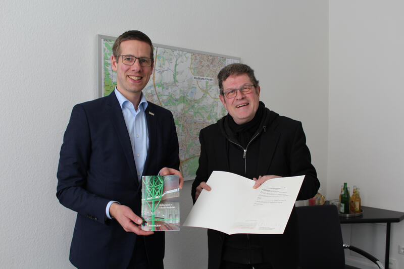 Bürgermeister Christoph Schultz (l.) überreicht Pfarrer Biskupek (r.) die Urkunde zum Denkmalschutz der Heilig-Geist-Kirche in Hochdahl.