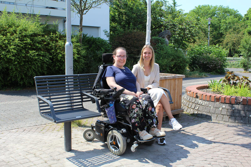 Die städtische Behindertenbeauftragte Katja Fellenberg (li.) und Citymanagerin Katharina Salzburg (re.) freuen sich über die neue Generationenbank am Bavier Platz in Alt-Erkrath.