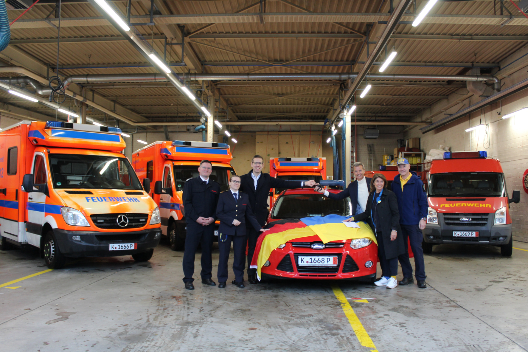 Feuerwehr- und Rettungswagen werden vom Bürgermeister und der Feuerwehr Erkrath überreicht mit deutscher und ukrainischer Flagge.