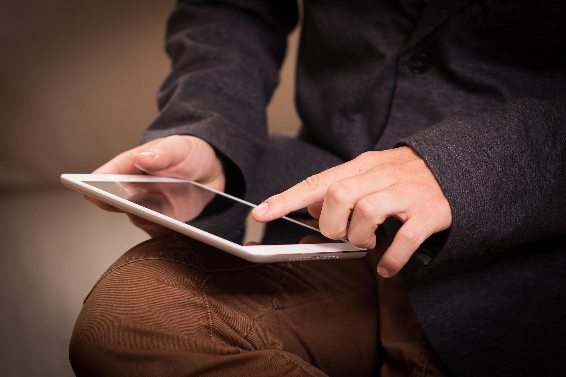 Eine Person bedient ein Tablet.