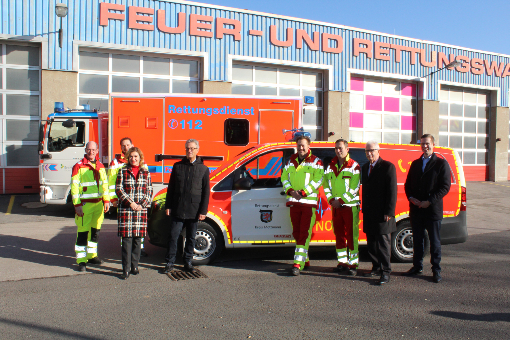 Bürgermeister Christoph Schultz, Landrat Thomas Hendele und weitere Personen stehen vor der Feuer- und Rettungswache mit neuen Notarzteinsatzfahrzeugen
