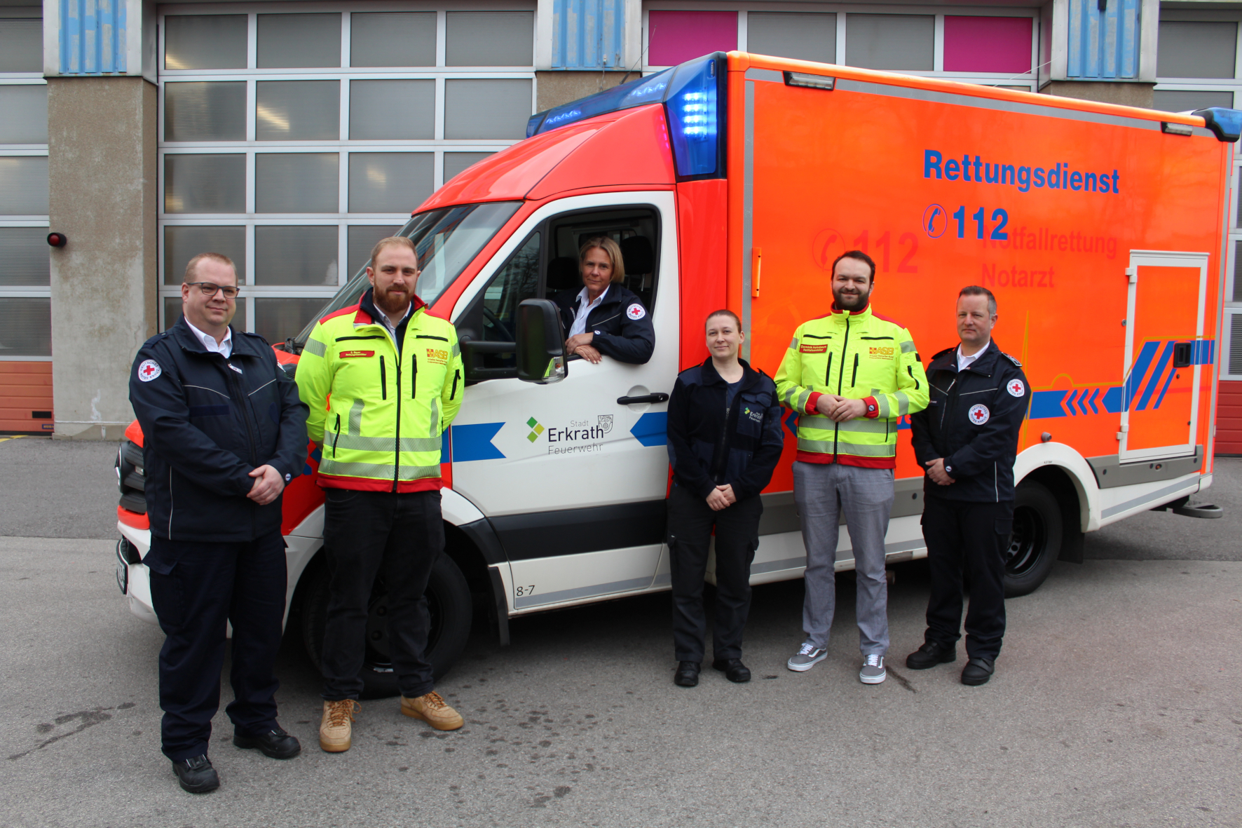 Neue Rettungskräfte vor einem Rettungswagen