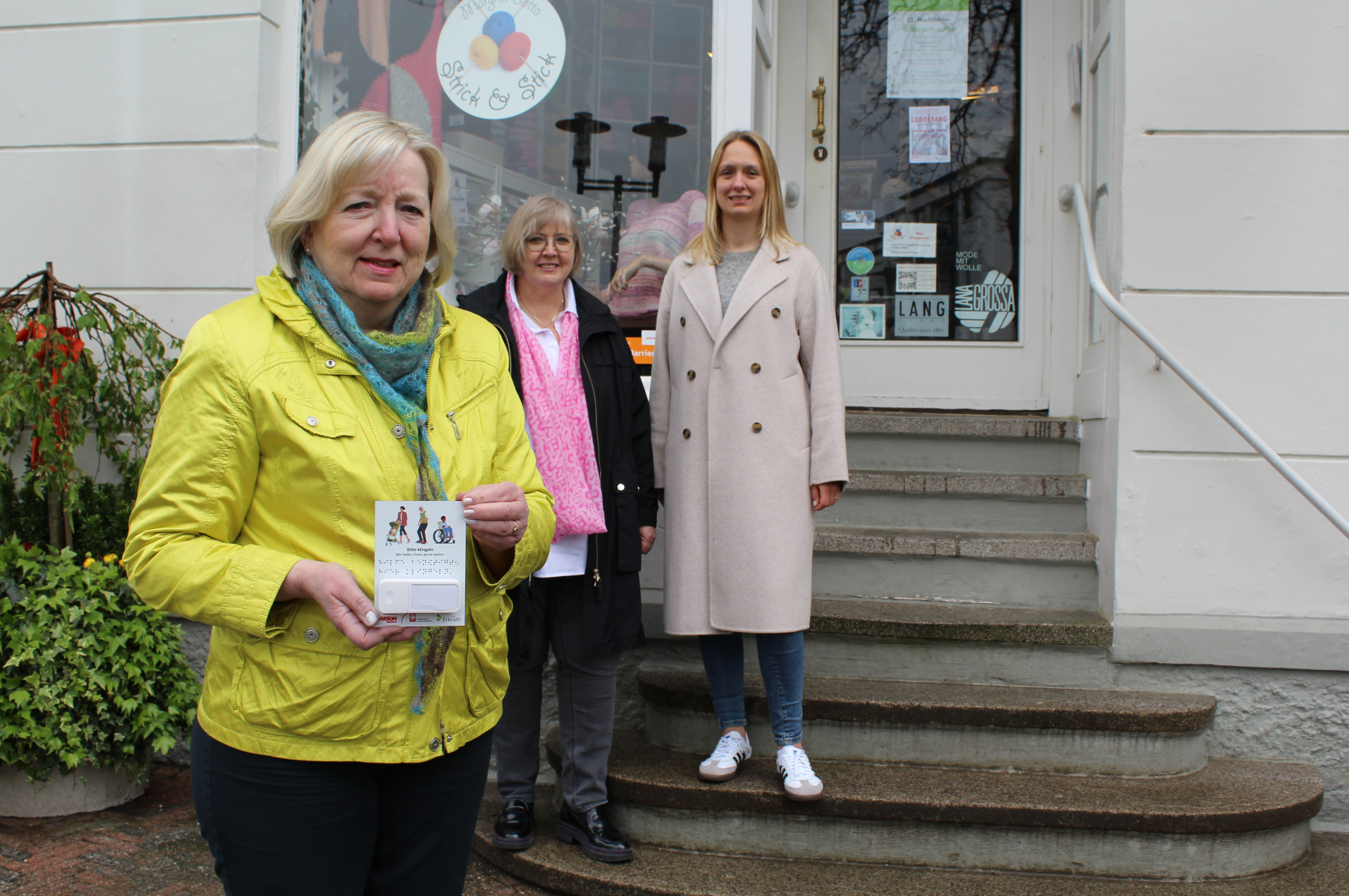 Margret Botta, Inhaberin des Ladenlokals Strick & Stick (1.v.l.), Gabriela Wolpers, Leiterin der Caritas-Begegnungsstätte an der Gerberstraße (2.v.l.) und Citymanagerin Katharina Salzburg (3.v.l.) präsentieren die Funkklingel.