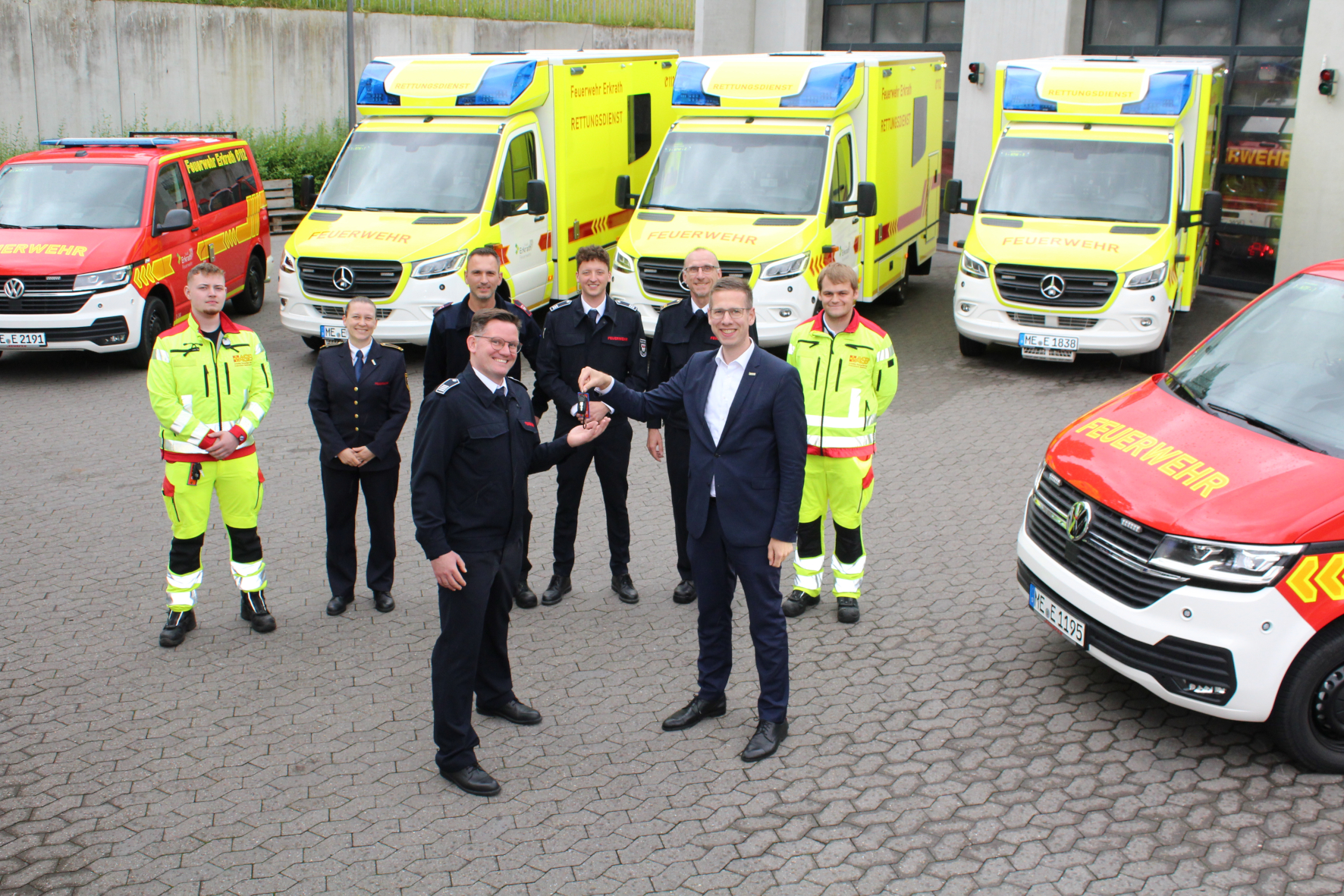 Bürgermeister Christoph Schultz übergibt Schlüssel neuer Einsatzfahrzeuge. Im Hintergrund stehen die neuen Fahrzeuge für den Rettungsdienst.
