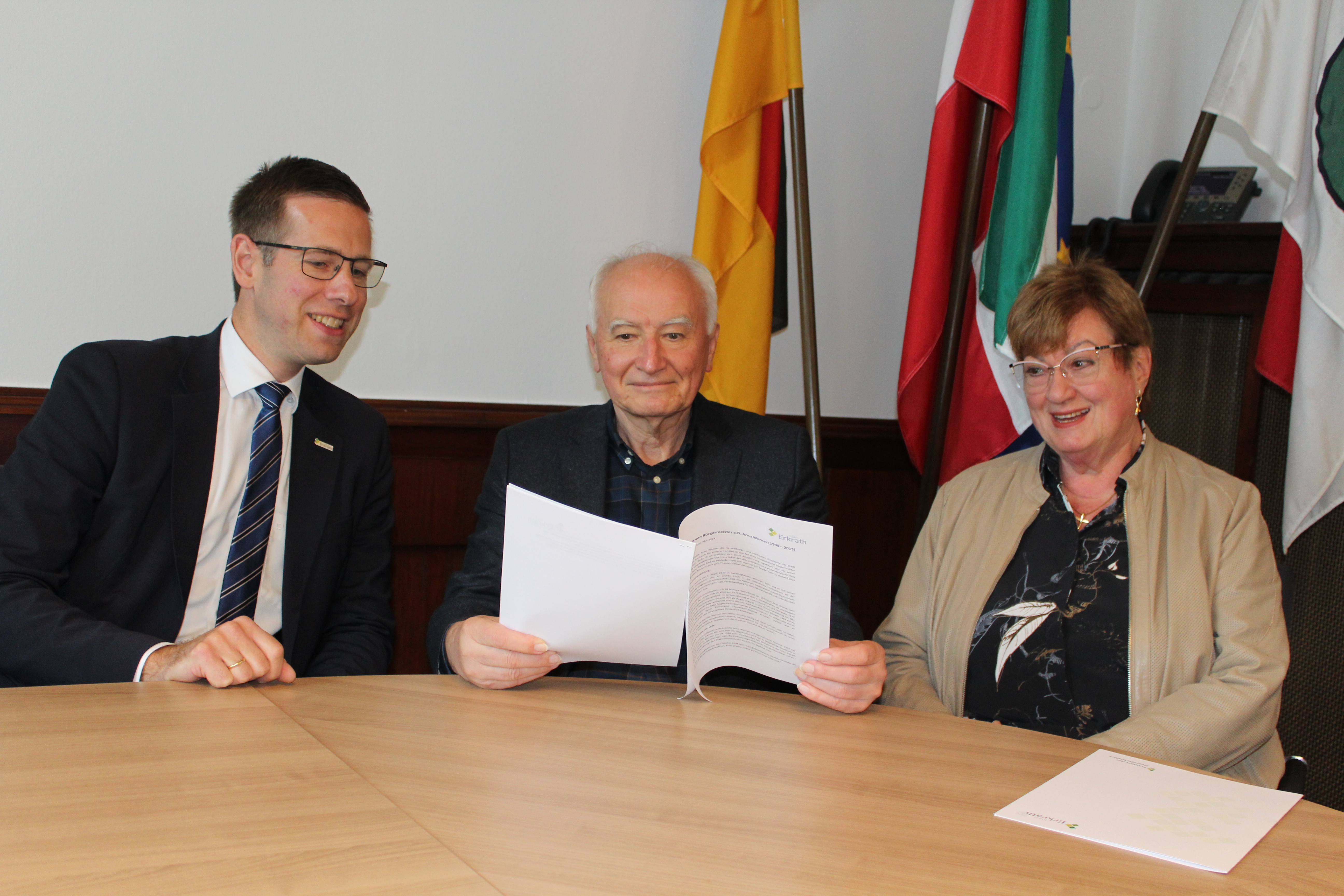 Gratulation zum 25-jährigen Jubiläum von Arno Werner vor Flaggen