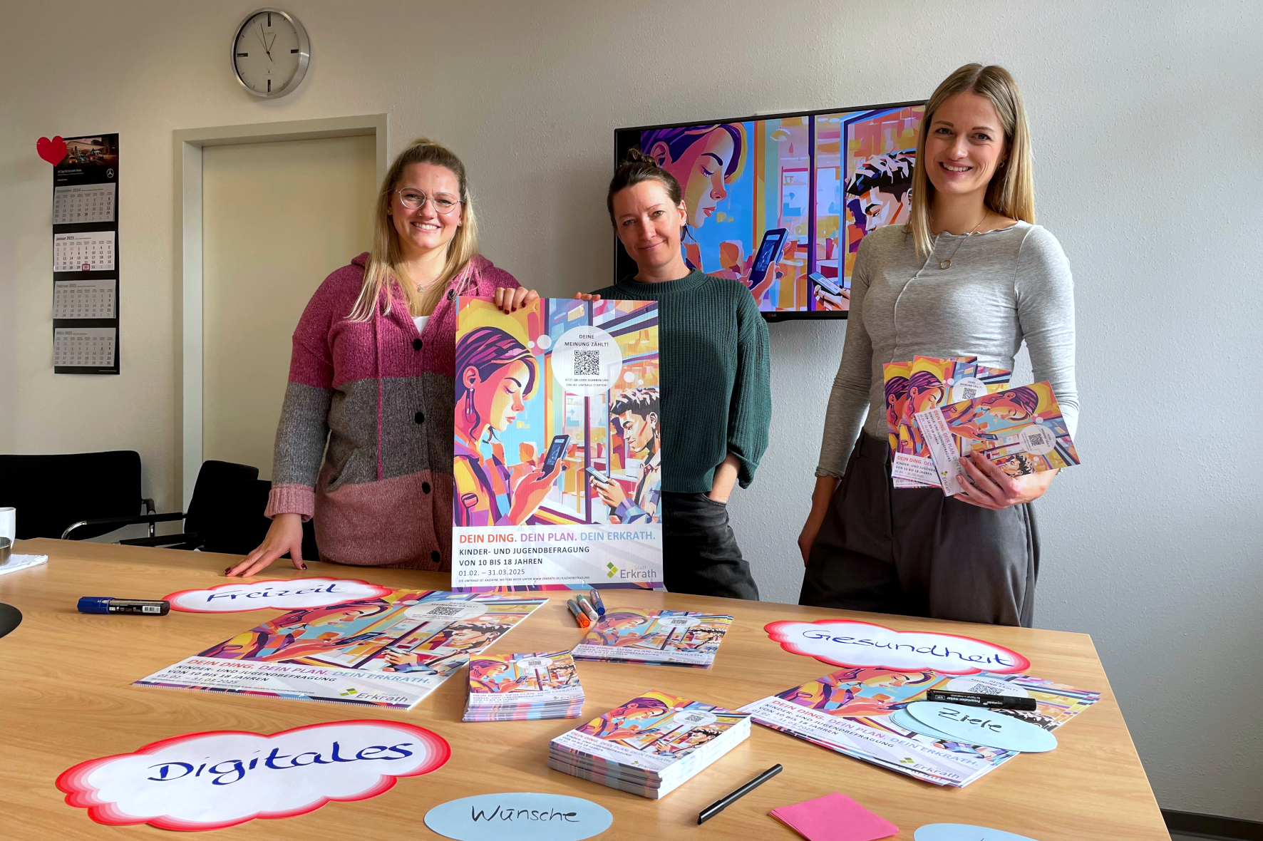 Die städtischen Mitarbeiterinnen Denise Kuhn, Jana Brakemeier und Julia stehen vor Postern der Jugendbefragung 2025.