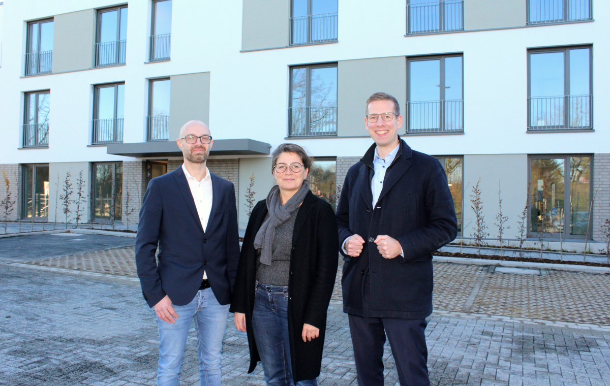 Bürgermeister Schultz, Beigeordnete Beck und Barthel freuen sich vor den neuen Wohneinheiten am Maiblümchen in Unterfeldhaus