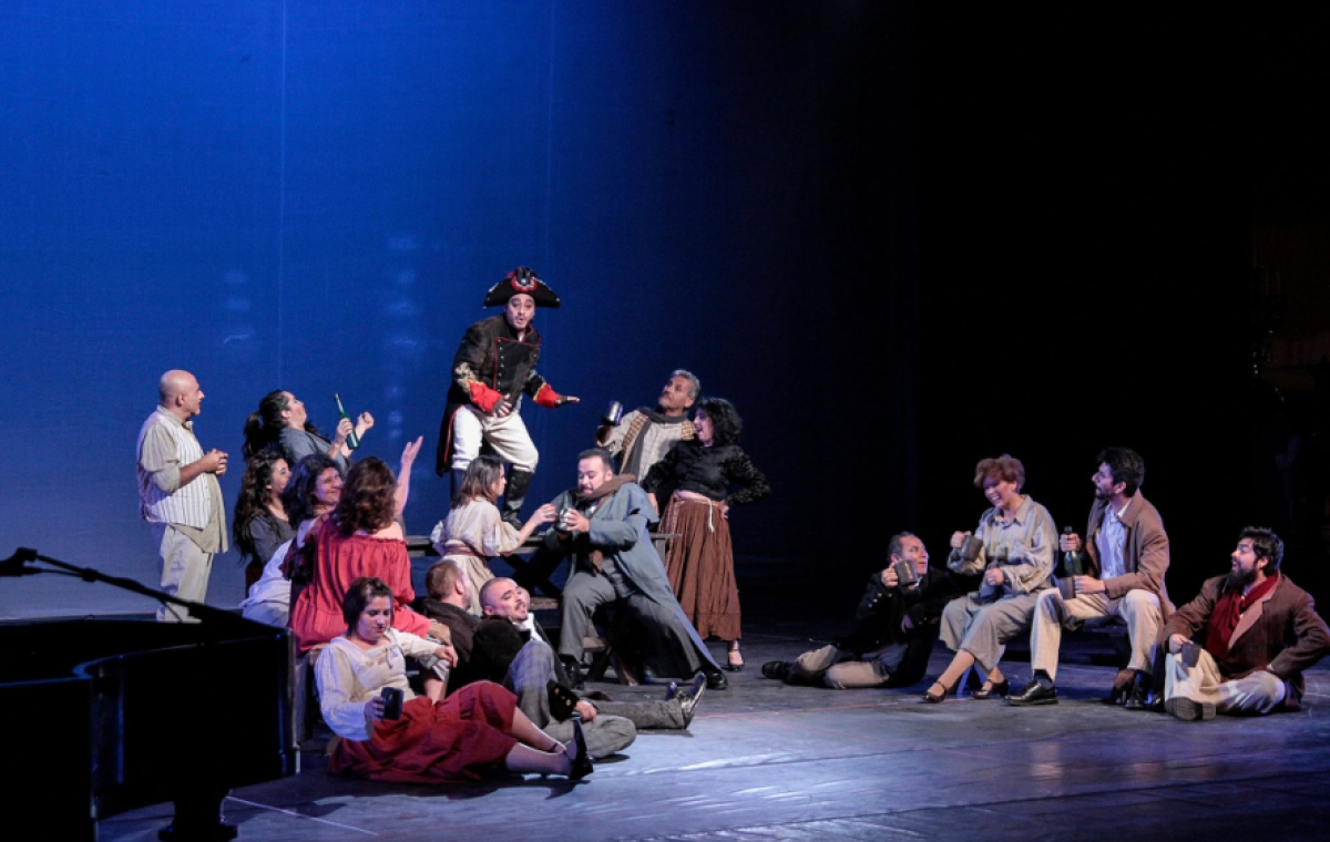 Ein gutes Dutzend Leute spielen eine Szene in einem Theaterstück