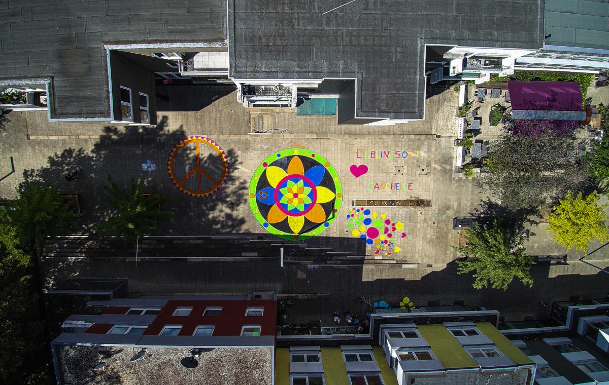 Eine Luftaufnahme von bunten Mandalas auf dem Sandheider Markt. Foto: Robin Schäfer