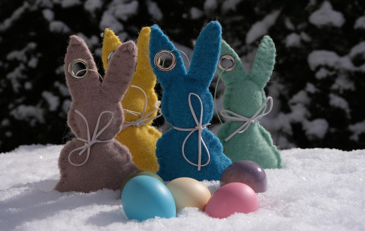 Bunte Osterhasen aus Filz mit kleinen bunten Ostereiern davor