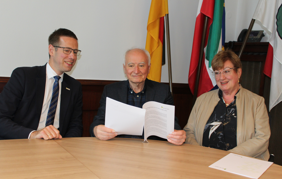 Gratulation zum 25-jährigen Jubiläum von Arno Werner vor Flaggen