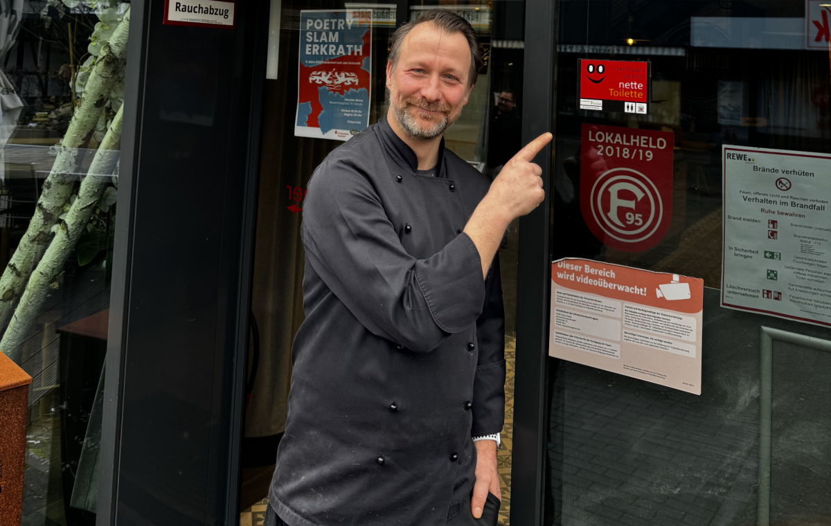 Stockies Gastronomieleiter Kai Uhlig zeigt auf einen Nette Toilette Aufkleber