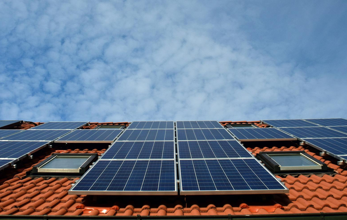 Ein rotes Ziegeldach mit Solarpanelen drauf