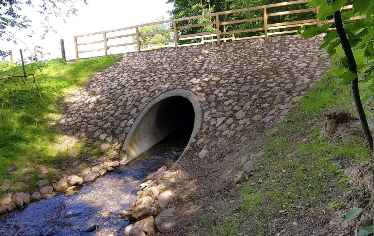 Die durch das Hochwasserereignis 2021 marode Brücke am Dorper Weg wurde zurückgebaut und durch ein neues Bauwerk mit Rohrdurchlass und überströmbarem Damm ersetzt.