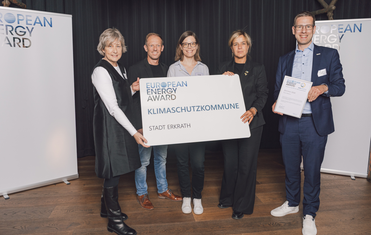 Mona Neubaur (2.v.r.) Ministerin für Wirtschaft, Industrie, Klimaschutz und Energie des Landes NRW, und Ilga Schwidder (1.v.l.), Geschäftsführerin der Bundesgeschäftsstelle des EEA, freuen sich gemeinsam mit Erkraths Bürgermeister Christoph Schultz (1.v.r.), Kristian Kuylaars (2.v.l.), Leiter des Fachbereichs Umweltschutz · Klimaschutz und Klimaschutzmanagerin Lena Brümmer (m.) über die erneute Auszeichnung der Stadt Erkrath mit dem European Energy Award.